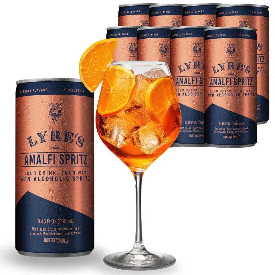 A can of Lyre's Amalfi Spritz non-alcoholic spirit drink is shown in front of a glass filled with an orange-colored drink and ice, garnished with orange slices, with additional cans of the same product arranged behind on a white background.